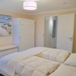 Schlafzimmer mit Bett, Kleiderschrank und Wandbild