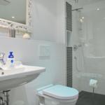Badezimmer mit Dusche, Waschbecken und Toilette.