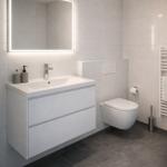 Badezimmer mit Waschbecken, Spiegel und WC. Fliesenboden und Wandfliesen.