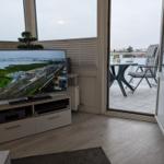 TV im Wohnzimmer mit Blick auf Balkon und Aussicht.