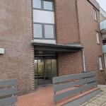 Eingangsbereich mit Glas-Tür und Rolltreppe an Backsteinhaus