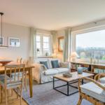 Wohn- und Essbereich mit Sofa, Esstisch und großem Fenster.