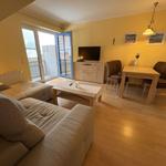 Wohn- und Essbereich mit Sofa, Esstisch und TV. Durchgang zur Terrasse.