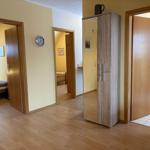 Flur mit Schlafzimmer, Bad und Kleiderschrank. Holzboden und gelbe Wände.