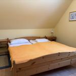 Schlafzimmer mit Holzbett, zwei Nachttischen und Lampen.