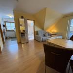 Wohn- und Essbereich mit Sofa, Esstisch und Blick auf Balkon.