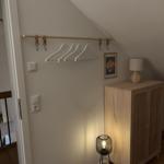 Schlafzimmer mit Kleiderständer, Schrank und Stehlampe unter Dachschrägen