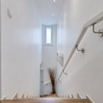 Helle Treppe mit Handlauf und Fenster im Obergeschoss