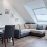 Wohn- und Essbereich mit Sofa, Tisch und Fenster