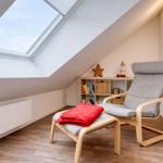 Dachgeschosszimmer mit Sitzgelegenheit und Dachfenster.