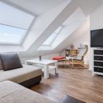 Wohnzimmer mit Dachschrägen, Sofa, Couchtisch und TV.
