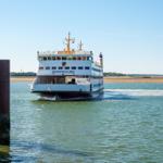 Fähre Nordfriesland fährt durch die Nordsee. Möwen fliegen über das Wasser.