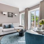 Wohnbereich mit Sofa, Esstisch und Blick auf Balkon