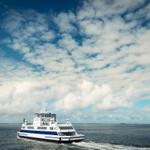 Ferries fährt über offenes Meer unter bewölktem Himmel.