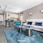 Wohnbereich mit Sofa, Sitzgelegenheiten und Küchenbereich.