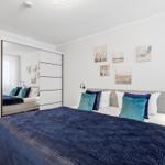 Schlafzimmer mit Bett, Kissen und Wandbildern