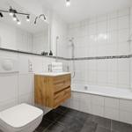 Badezimmer mit Badewanne, Dusche, Waschbecken und Toilette.