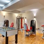 Fitnessraum mit Trainingsgeräten und Tischfußball.