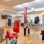 Fitnessraum mit Trainingsgeräten und Tischfußball