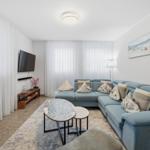 Wohnzimmer mit blauem Sofa, Couchtisch und Wandbild.