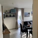 Küche mit Esstisch, Sofa und Fenster zum Balkon.