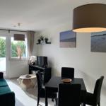 Wohn- und Essbereich mit Sofa, Esstisch und Wandbildern.