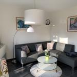 Wohnzimmer mit Sofa, Couchtisch und Stehlampe.