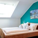 Schlafzimmer mit Dachschrägen, Dachfenster und Holzbett.