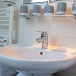 Waschbecken mit Wasserflaschen und Handtuchhalter im Badezimmer.