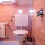 Bad mit Toilette, rosa Fliesen und Heizkörper