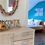Schrank mit Dekoration und Blick in Schlafzimmer mit blauer Wand