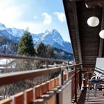 Terrasse mit Blick auf schneebedeckte Berge und Bäume.