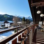 Terrasse mit Sicht auf schneebedeckte Berge und Dorf.