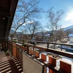 Terrasse mit Blick auf verschneite Berge und Häuser