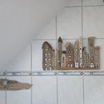 Driftwood-Hausdekoration an einer Fliesenwand mit Mosaikstreifen