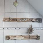 Wand mit Holzdekorationen, Muscheln und einem Herz an der Decke.