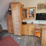 Zimmer mit Holzmöbeln, Fernseher und rotem Teppich