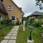 Haus mit Steinweg, Garten und Laterne. Name Mary an der Wand.