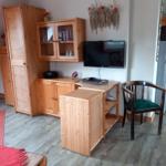 Wohnzimmer mit Holzmöbeln, Fernseher und Stuhl