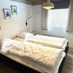 Schlafzimmer mit Bett, Fenster und Wandbildern.