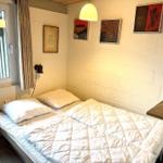 Schlafzimmer mit Bett, Wandbildern und Fenster.