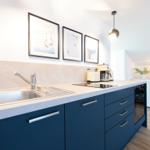 Küche mit blauen Schränken, Edelstahlspüle und Küchenzeile