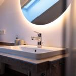 Waschbecken mit Spiegel und Handtuchstapel