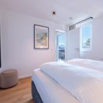 Schlafzimmer mit Doppelbett, Fenster und Balkontür.