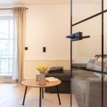 Wohnbereich mit Sofa, Tisch und Blick auf Balkon