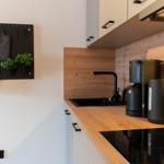 Küche mit Holz Arbeitsplatte, Spüle, Kaffeemaschine und Wasserkocher.