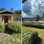 Haus mit Vorgarten und Blick auf bewaldete Hügel unter dramatischem Himmel.