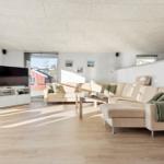 Living room with sofa, TV, and wooden floor. Access to terrace.