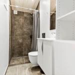 Bathroom with shower, toilet, and sink.