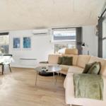 Living and dining area with sofa, table, and windows.